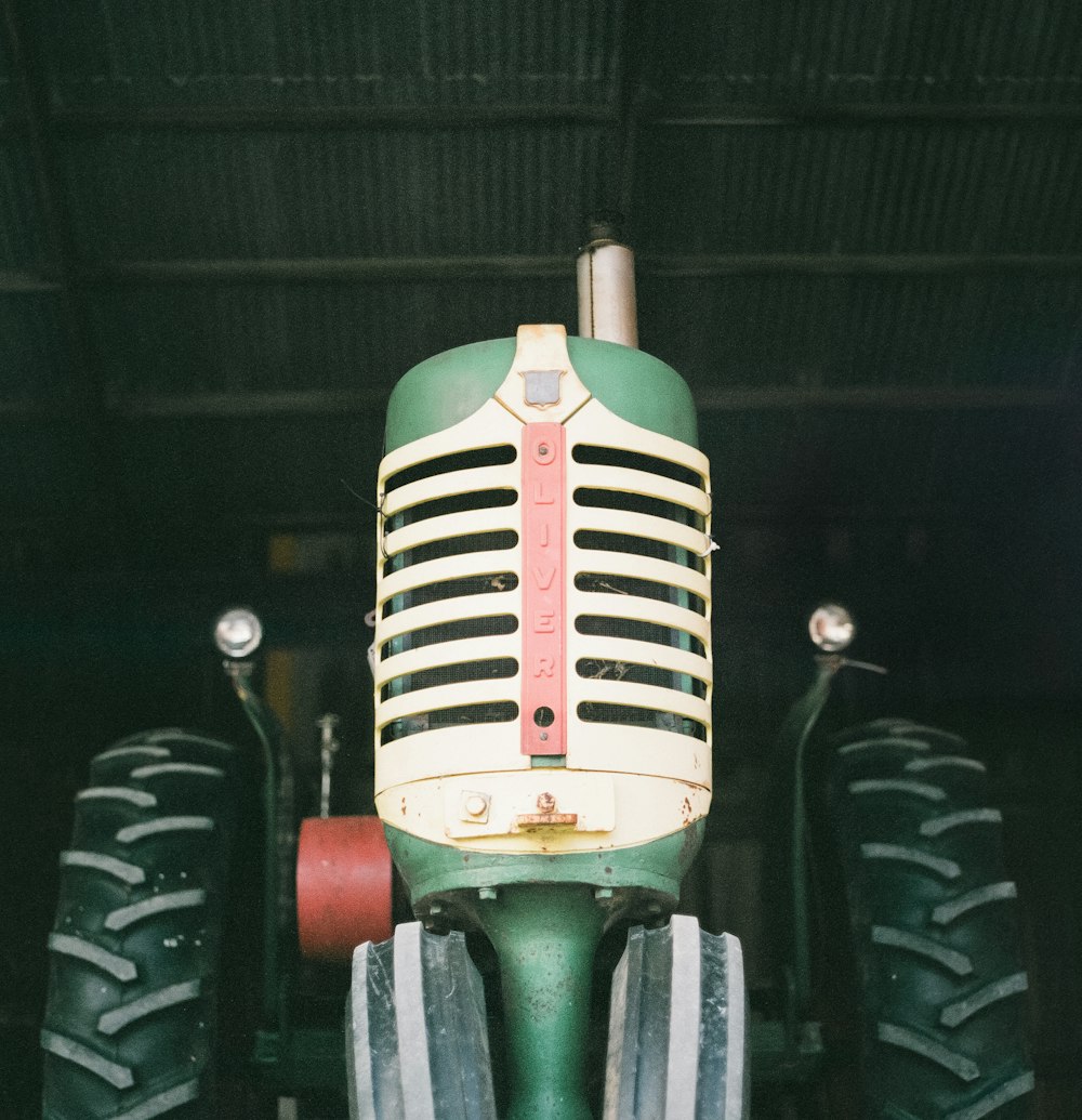 a green and white tractor sitting inside of a garage