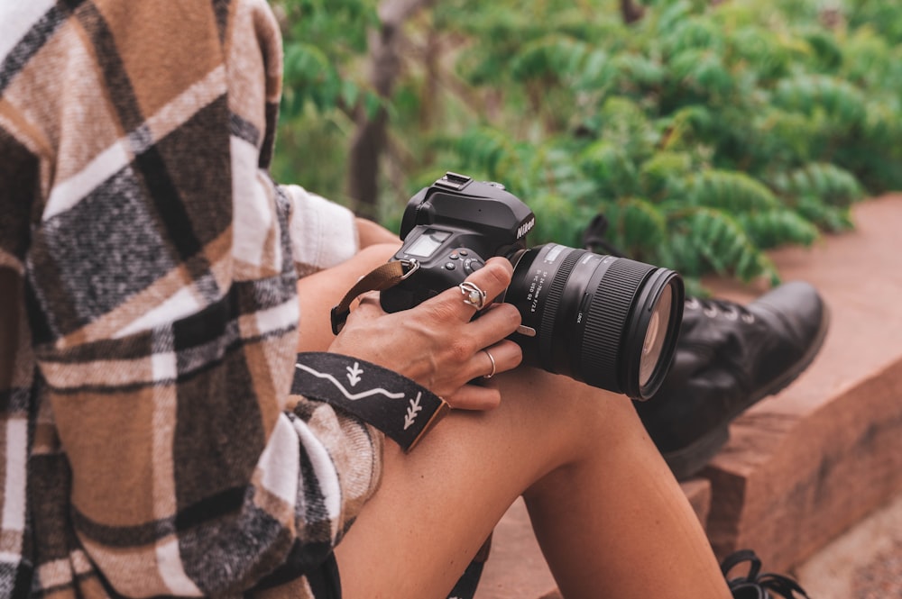 a woman sitting on a bench holding a camera