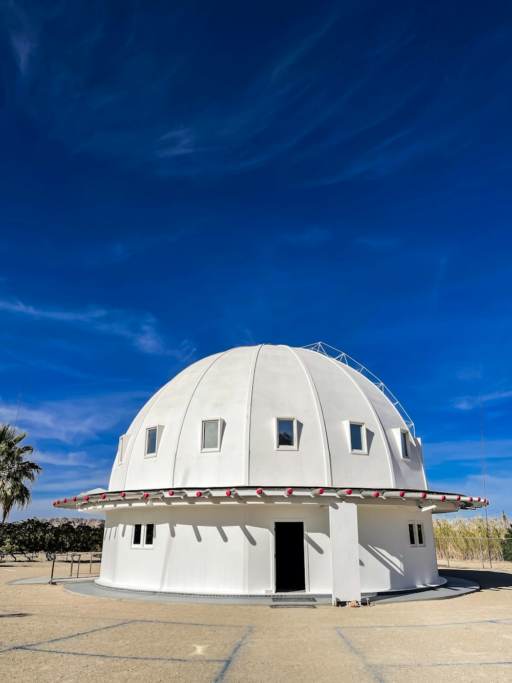 una grande struttura a cupola bianca seduta in cima a un campo di cemento