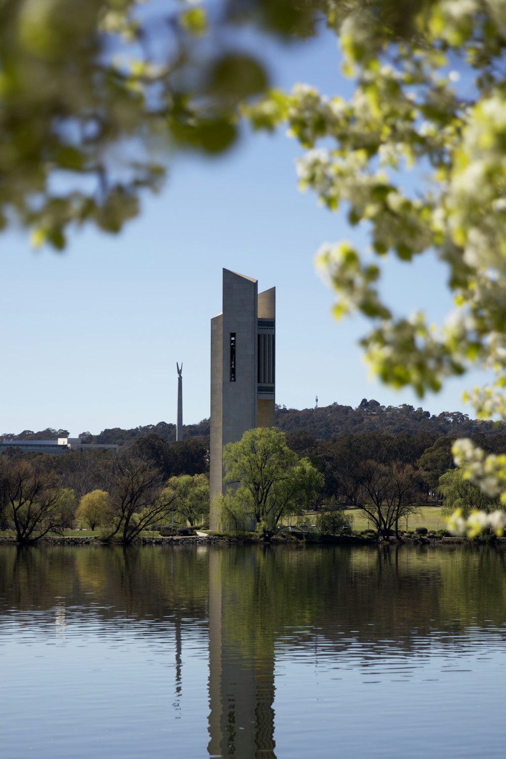 una torre de reloj sentada en la orilla de un lago