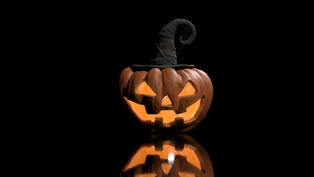a carved pumpkin with a black hat on top of it
