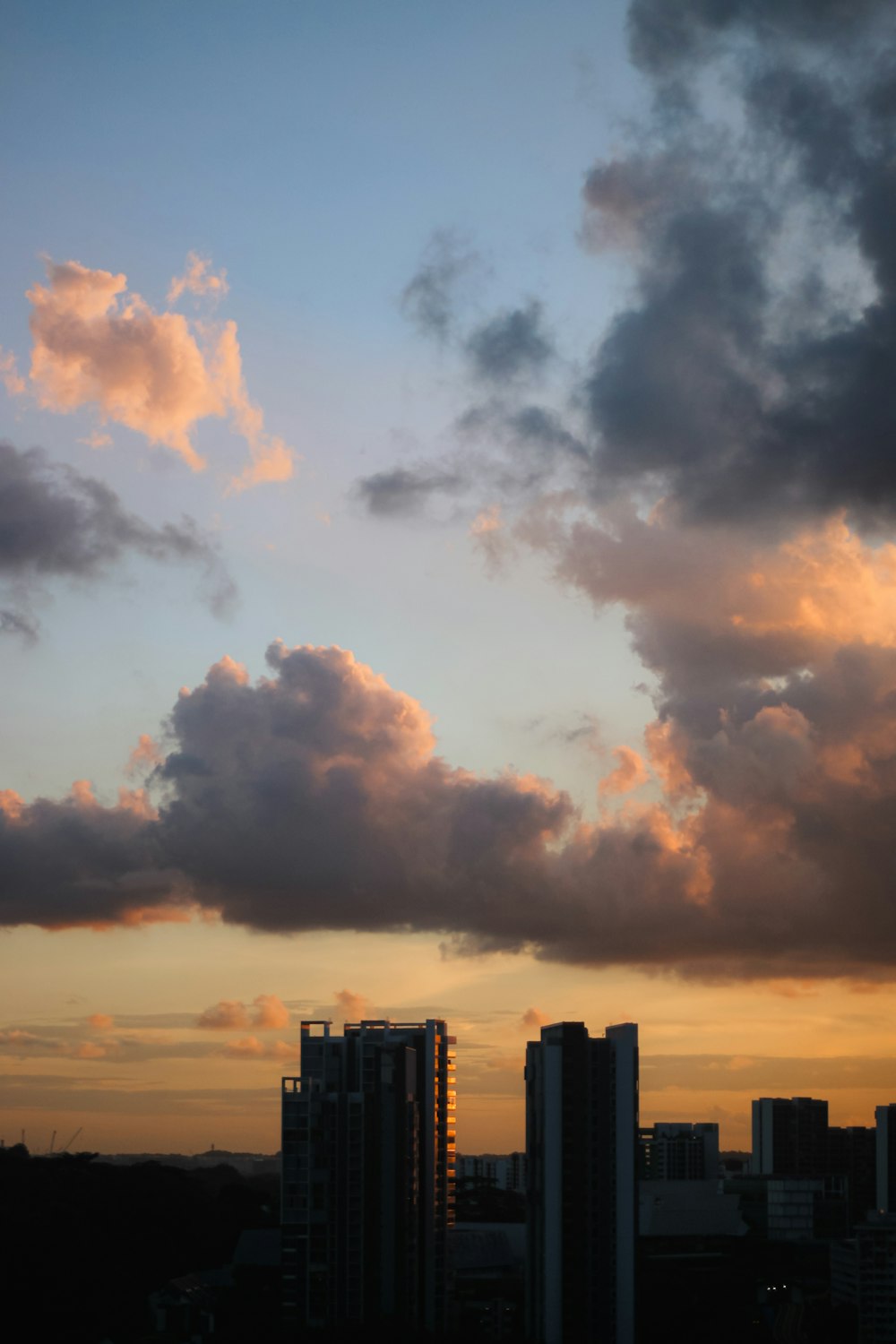 a view of a city at sunset with clouds in the sky