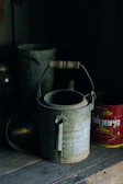 Close-up of a vintage-style metal watering can with water droplets on its surface.