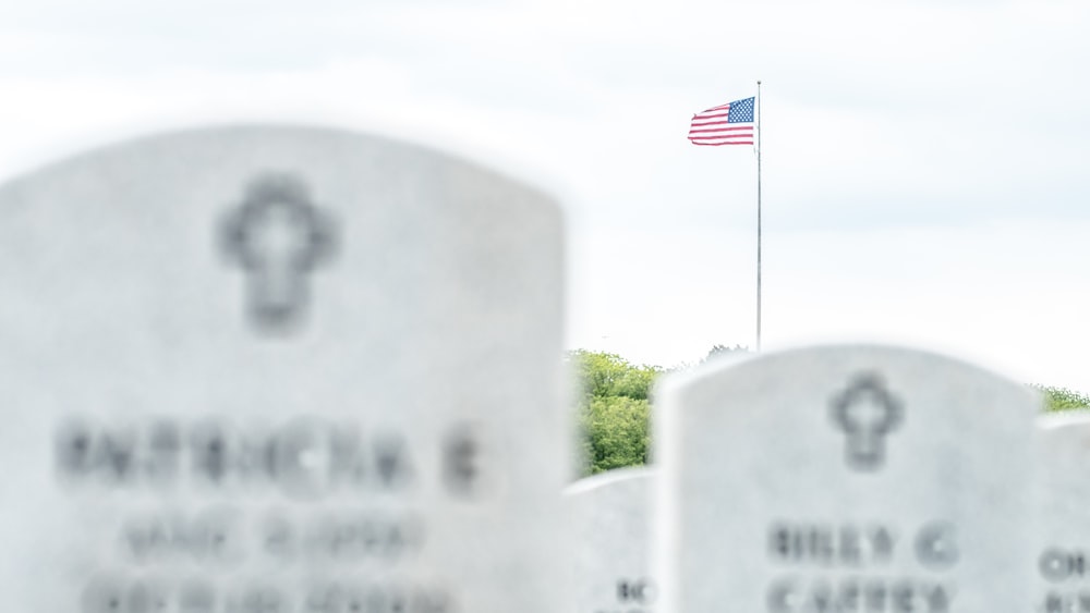 a flag flying over a cemetery with headstones