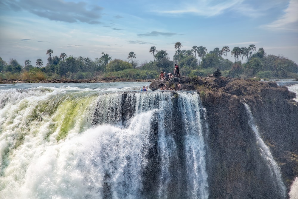 a group of people standing on top of a waterfall