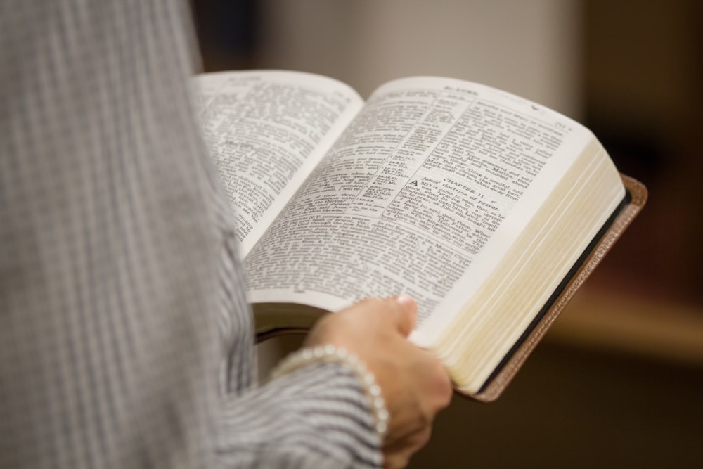 a person holding an open book in their hands