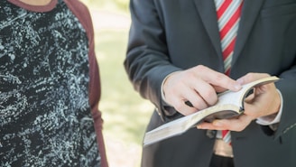 a man in a suit and tie holding a book