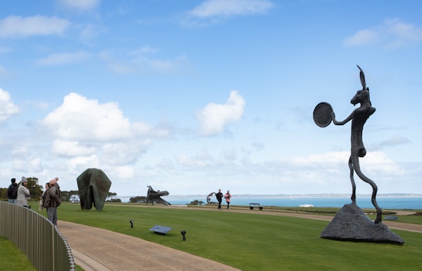 Volunteers setting up an outdoor art exhibit under a clear blue sky in Manhattan Beach.