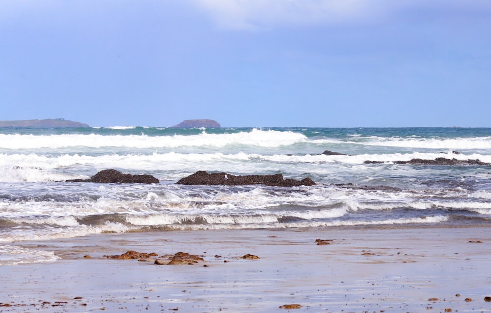 a person walking on the beach with a surfboard