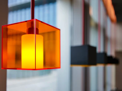 a red light hanging from a ceiling next to a window