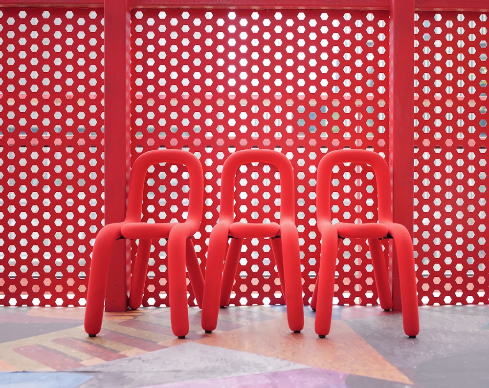 a group of red chairs sitting next to each other