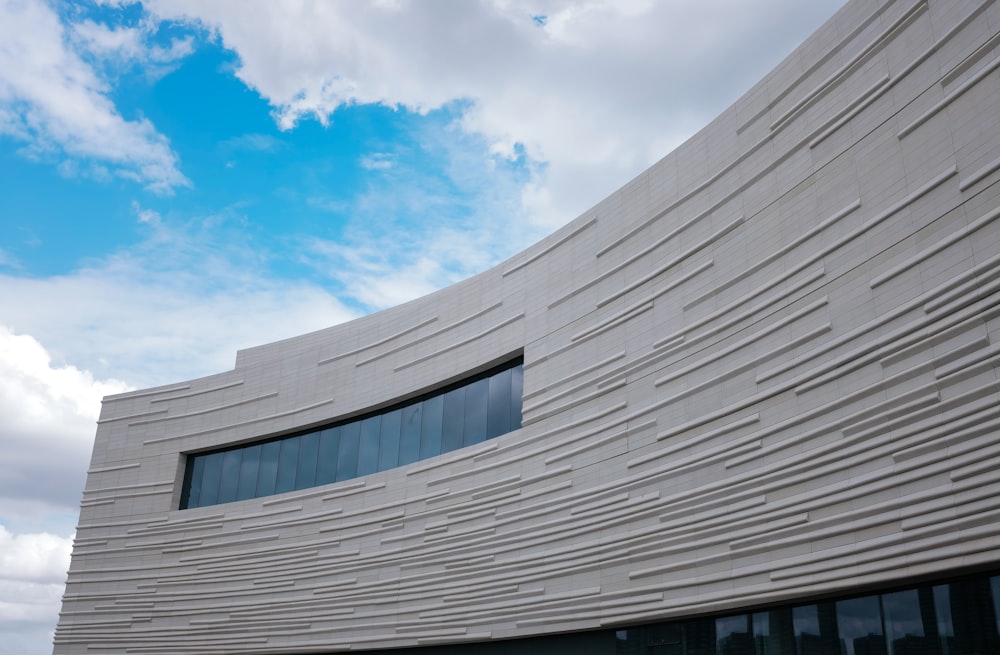 a building with a curved wall and a sky background