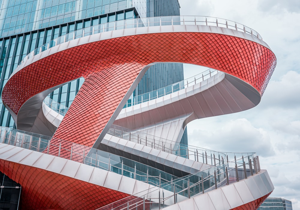 a red and white spiral staircase in front of a tall building