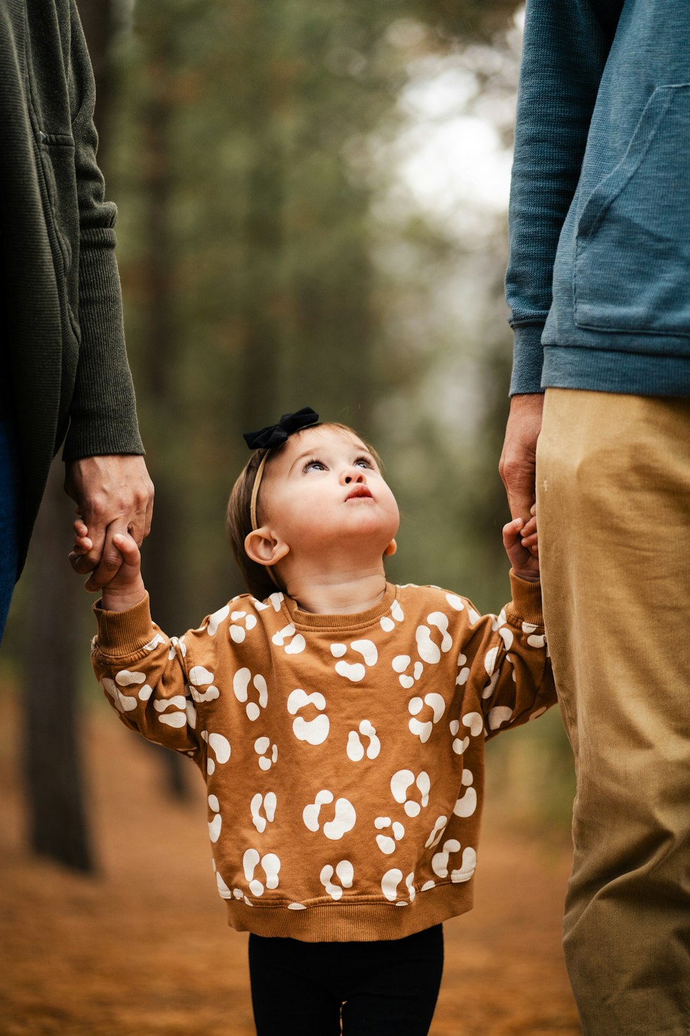 a little girl holding the hand of a man