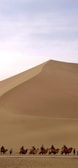 A group of travelers enjoying a camel ride in the desert.