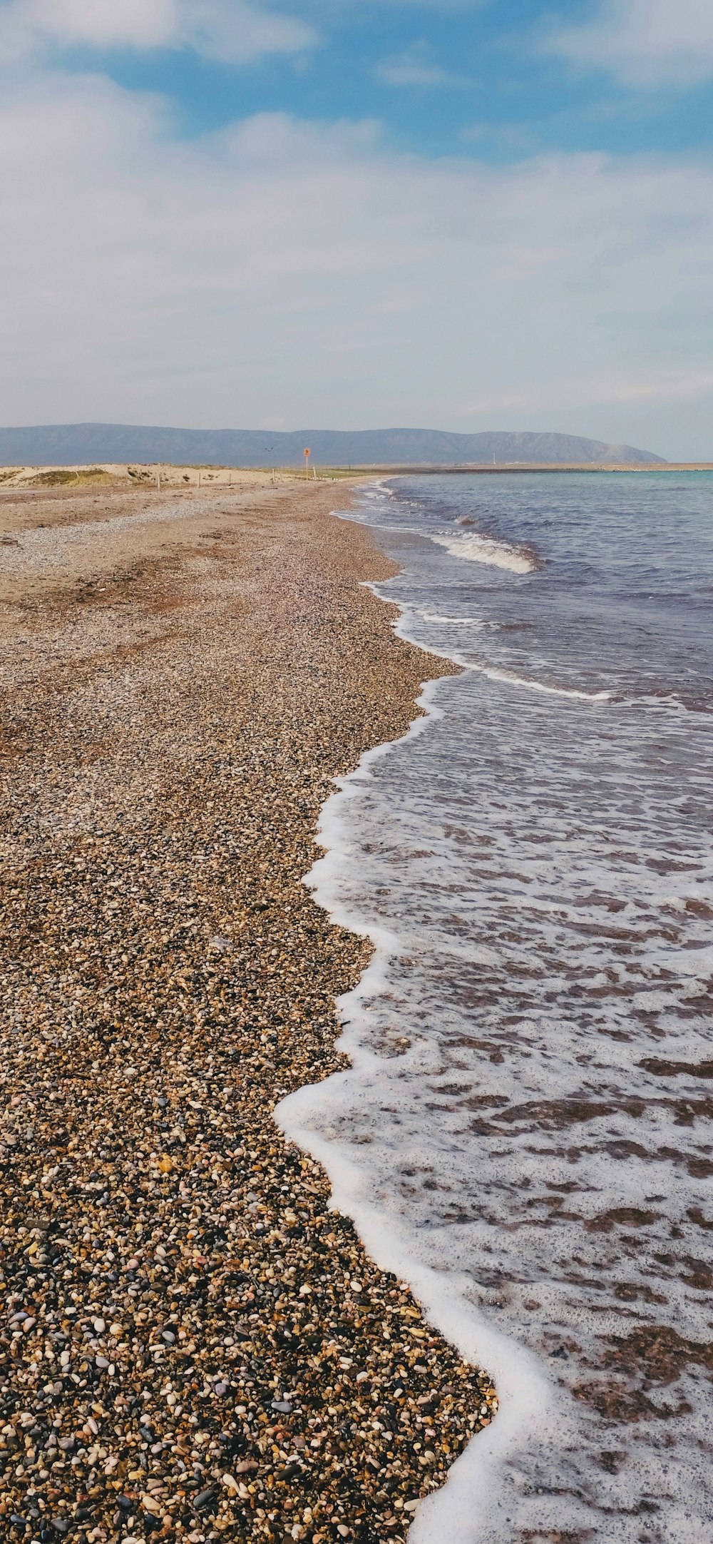 a sandy beach with waves coming in to shore