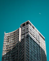 Modern high-rise building under moonlight with sleek architectural lines.
