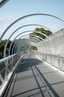A sleek PRFV pultruded pedestrian bridge with modern guardrails under a clear blue sky