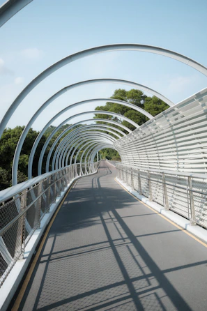 A sleek PRFV pultruded pedestrian bridge with modern guardrails under a clear blue sky