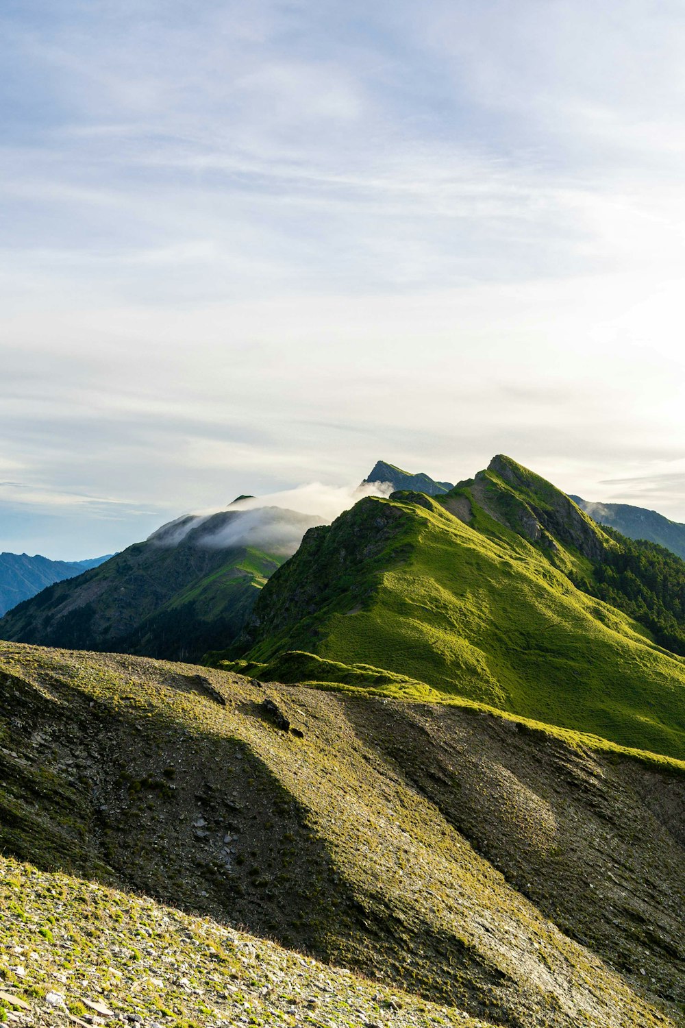 a view of a mountain range with a few clouds in the sky