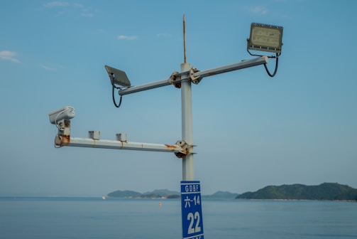 Security camera mounted on a pole overlooking parked boats and trailers.