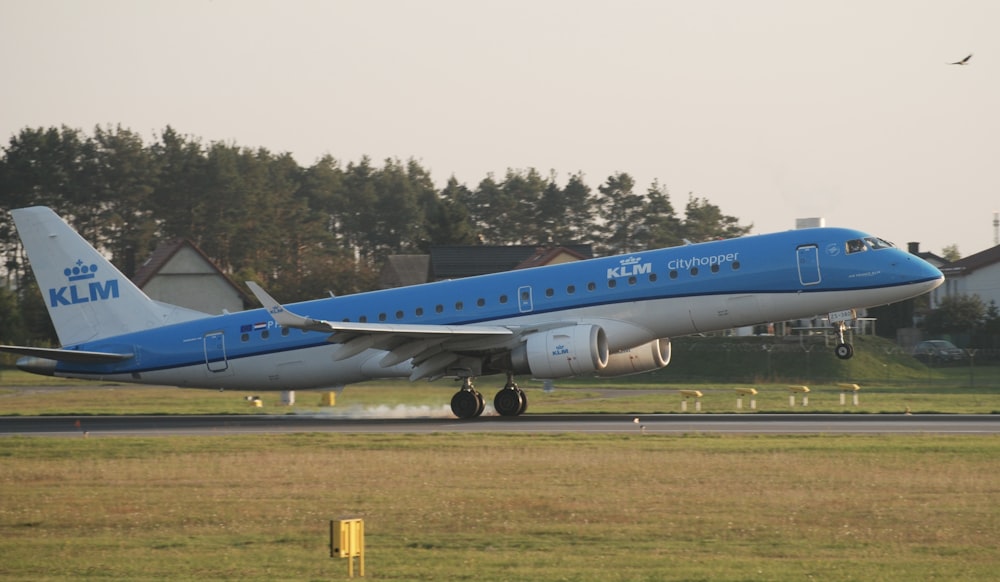 a blue and white airplane is on the runway