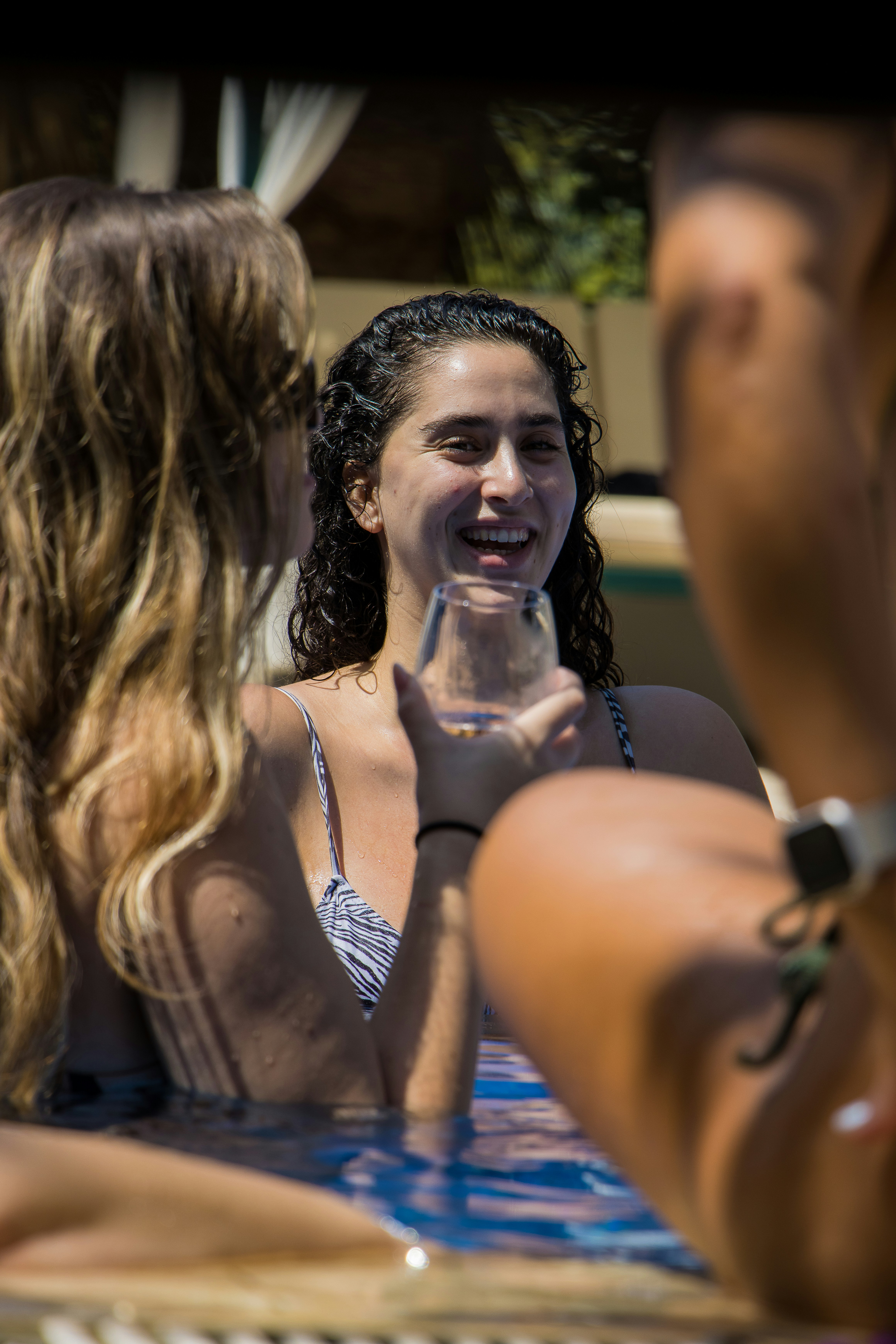 eine Frau im Badeanzug, die ein Glas Wein in der Hand hält