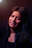 Round avatar of a smiling young woman with short hair, glowing softly against a dark indigo background.