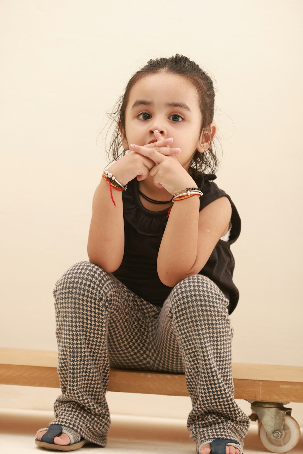 a little girl sitting on a wooden bench