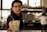 A bartender offering a cocktail in a glass with a Havana Club logo, accompanied by a bottle of Frontera Cabernet Sauvignon on the counter, with a blurred background.
