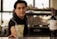 A bartender offering a cocktail in a glass with a Havana Club logo, accompanied by a bottle of Frontera Cabernet Sauvignon on the counter, with a blurred background.