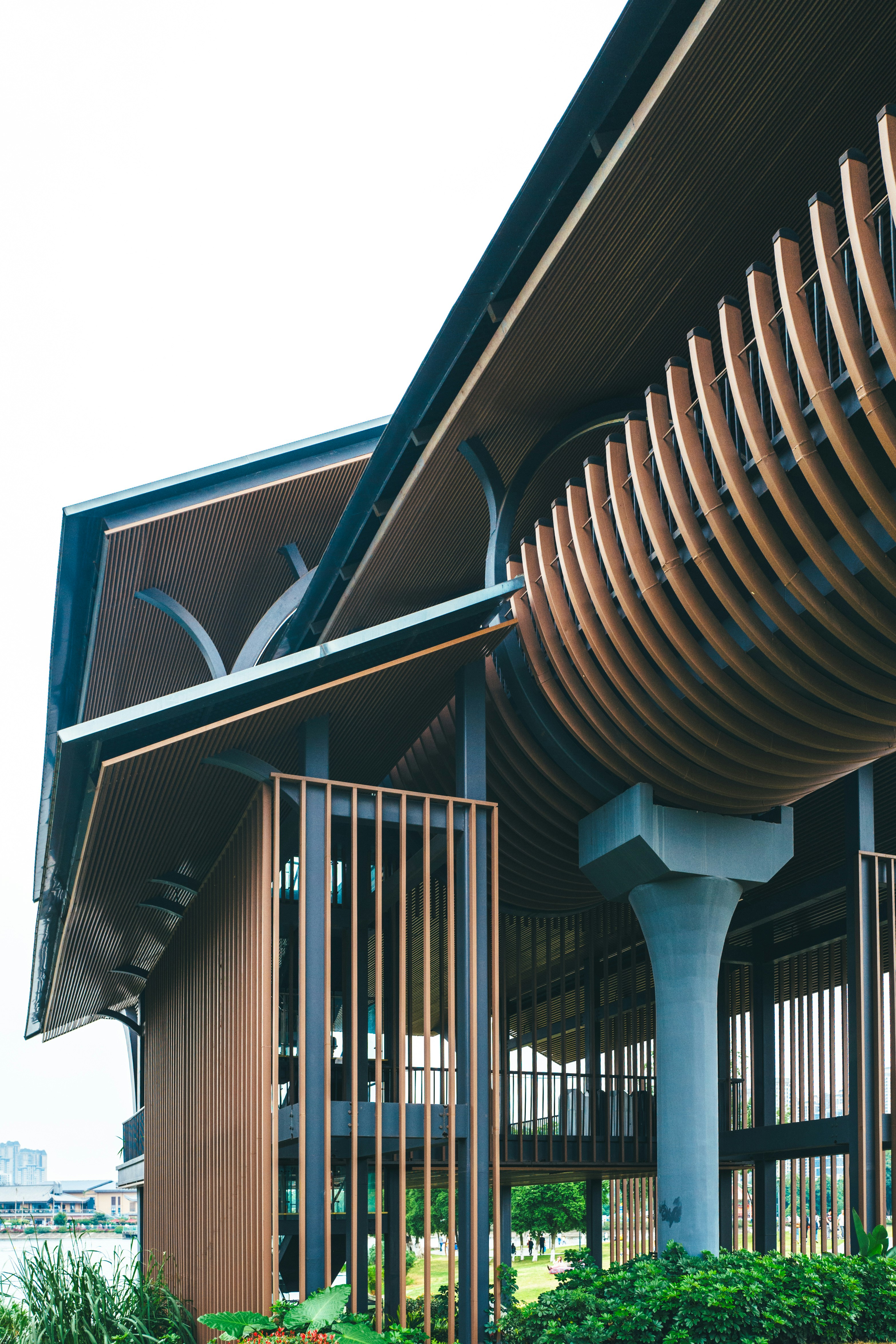 a building with a curved wooden roof and metal railings