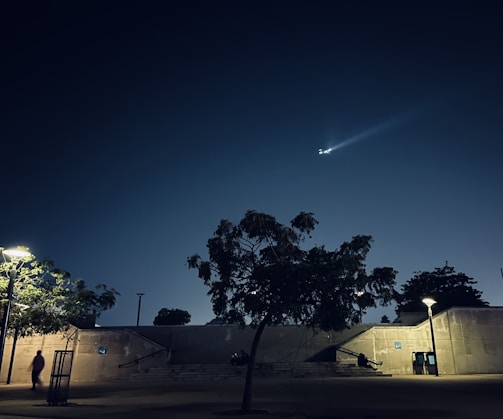Nighttime urban rooftop scene with drones equipped with bright lights ready for deployment.