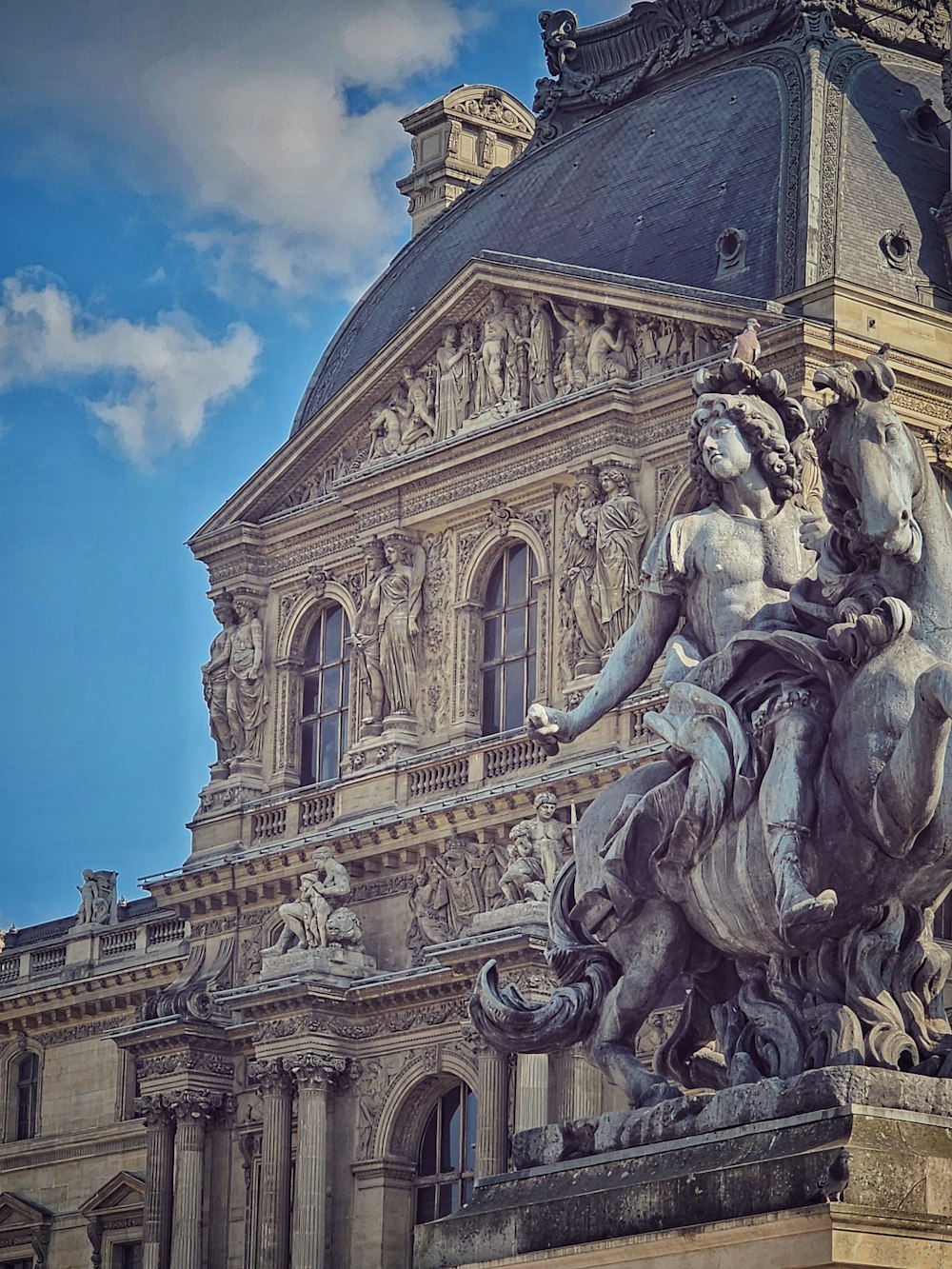 a statue of a woman riding a horse in front of a building