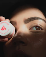 a woman putting a cream on her eye