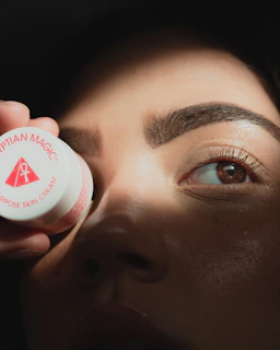a woman putting a cream on her eye