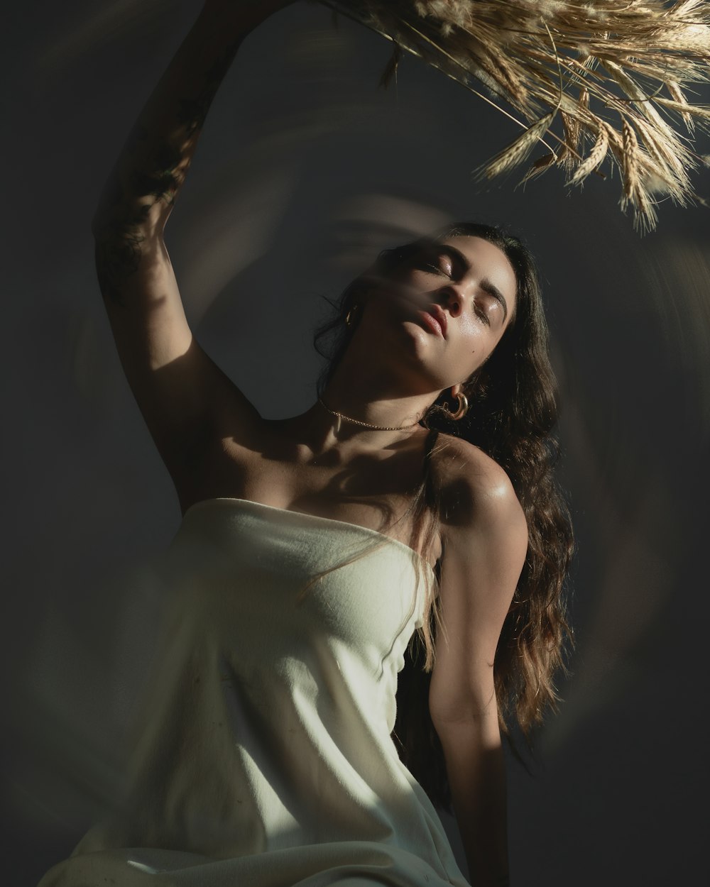 a woman in a white dress holding a plant