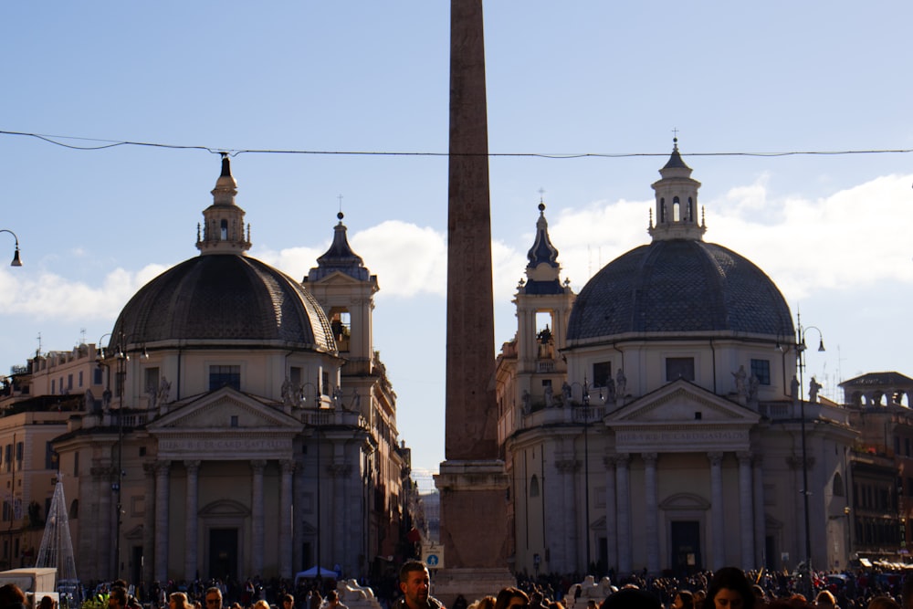 Eine Gruppe von Menschen steht vor einem hohen Obelisken