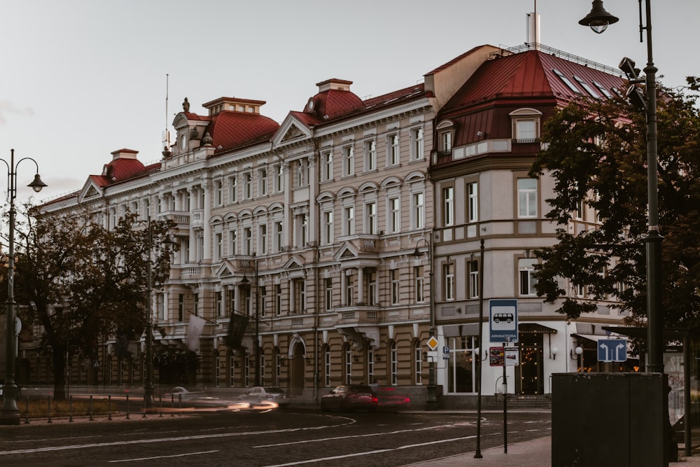 a large building with a red roof on a city street