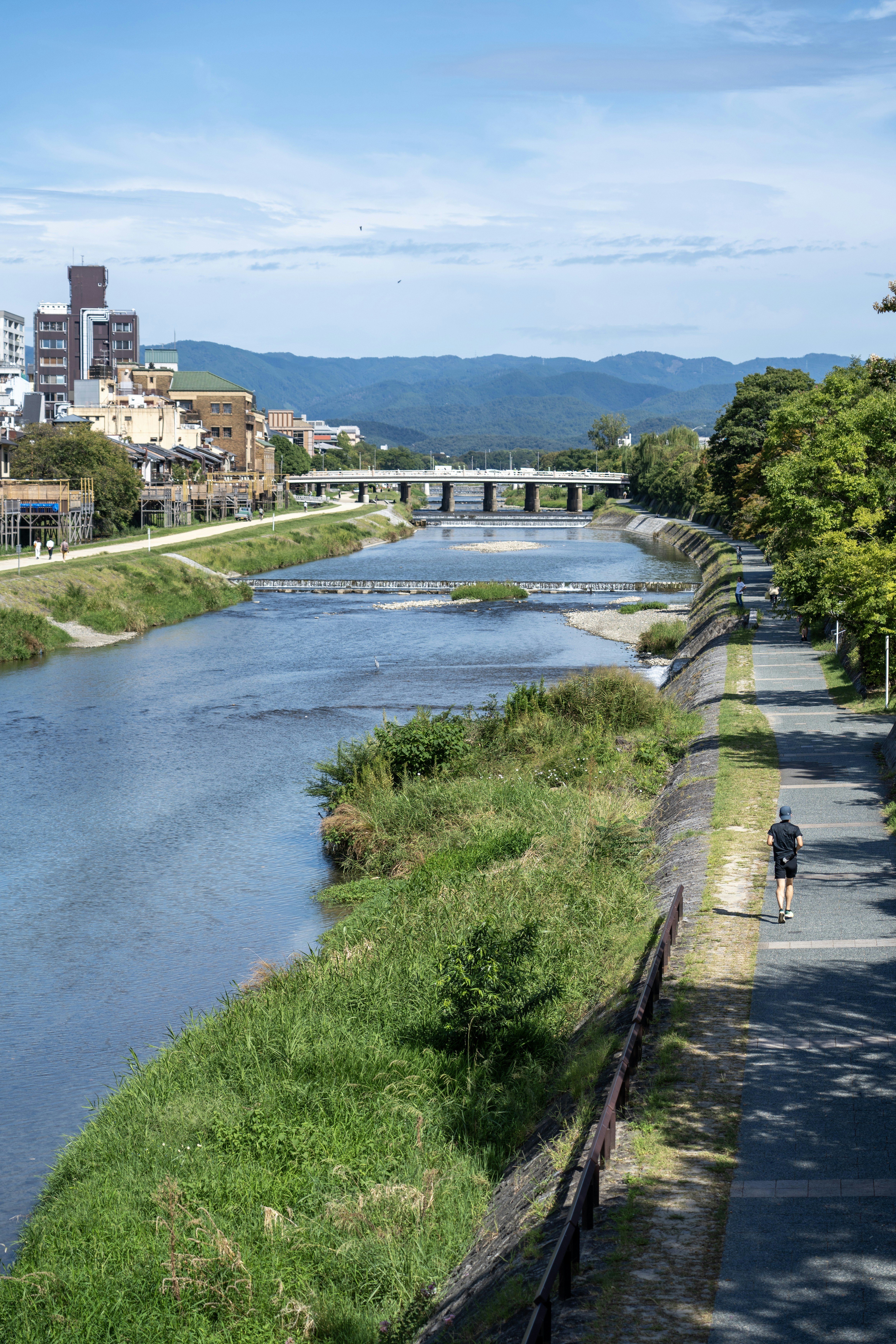 a man riding a bike down a street next to a river