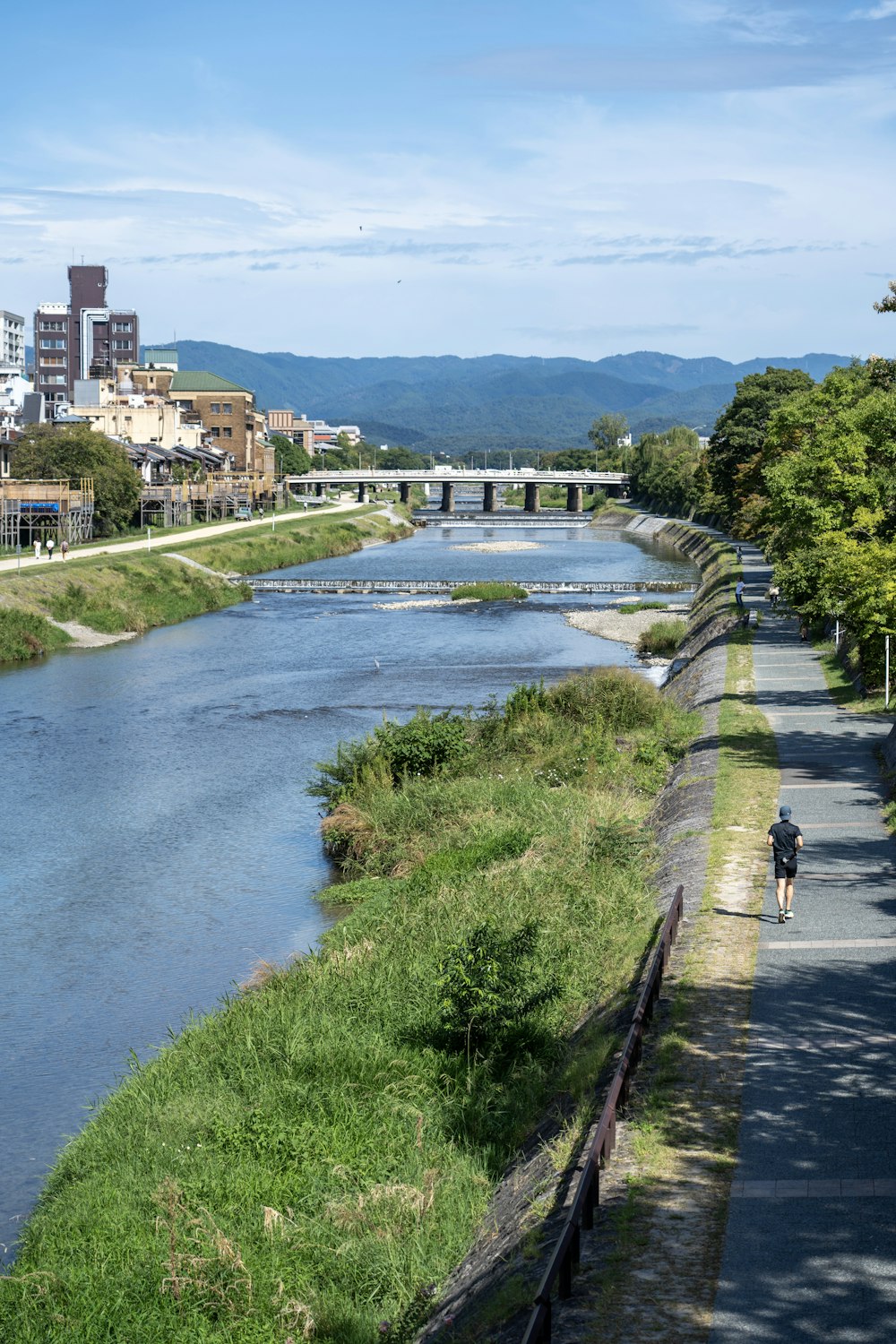 a man riding a bike down a street next to a river