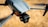 A close-up view of a modern drone capturing detailed design features such as the camera and wing structure. The background is blurred, highlighting the drone's sleek, aerodynamic body.