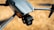 A close-up view of a modern drone capturing detailed design features such as the camera and wing structure. The background is blurred, highlighting the drone's sleek, aerodynamic body.
