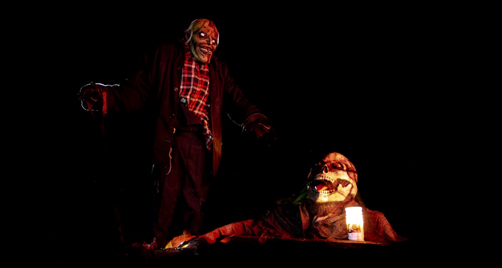 Un homme debout à côté d’un clown effrayant sur une scène