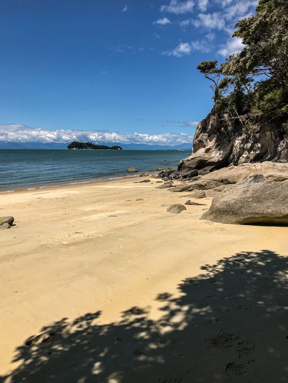 uma praia de areia ao lado do oceano sob um céu azul