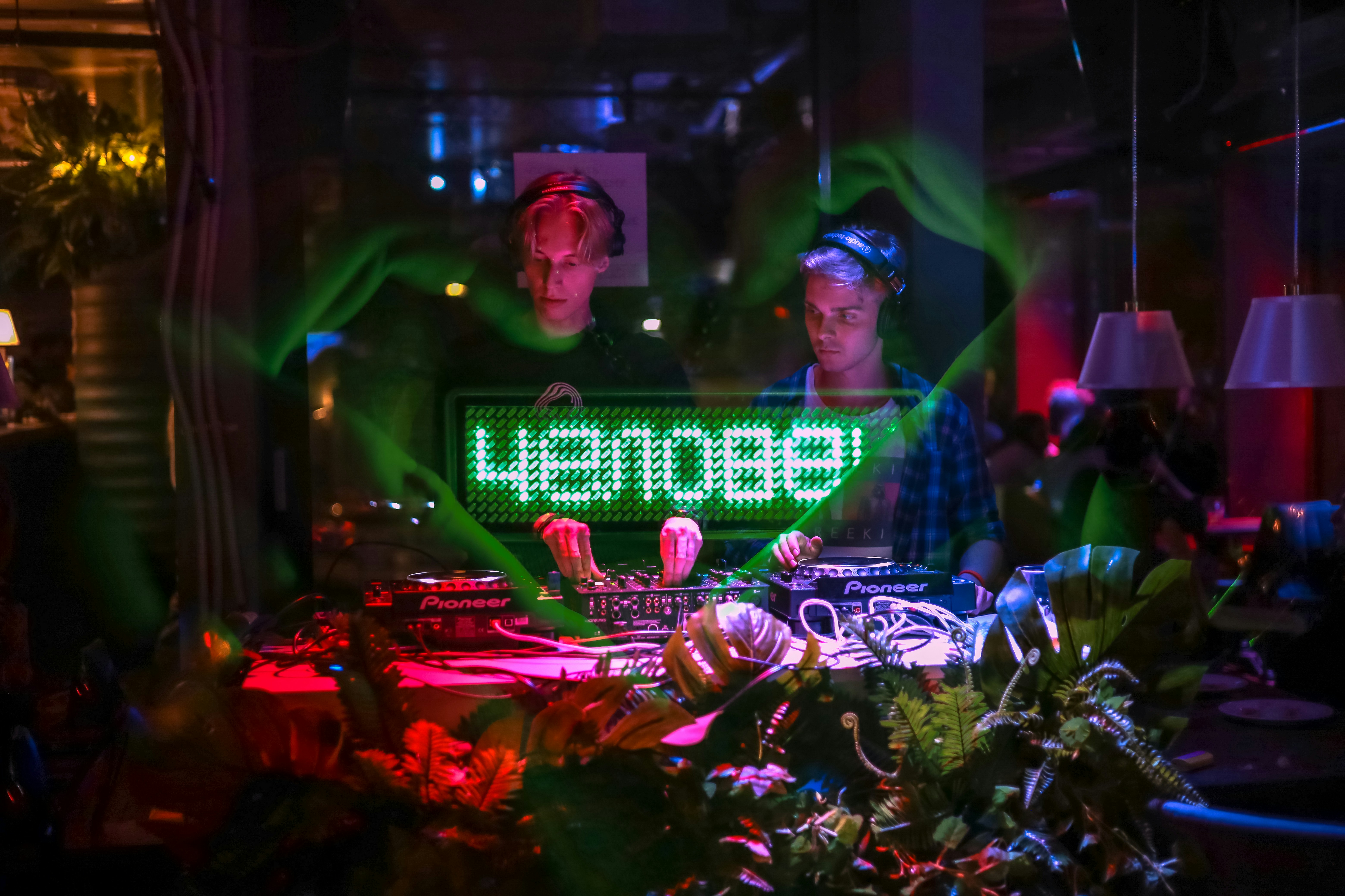 a couple of men standing next to each other in front of a neon …