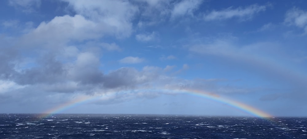 a rainbow in the sky over the ocean