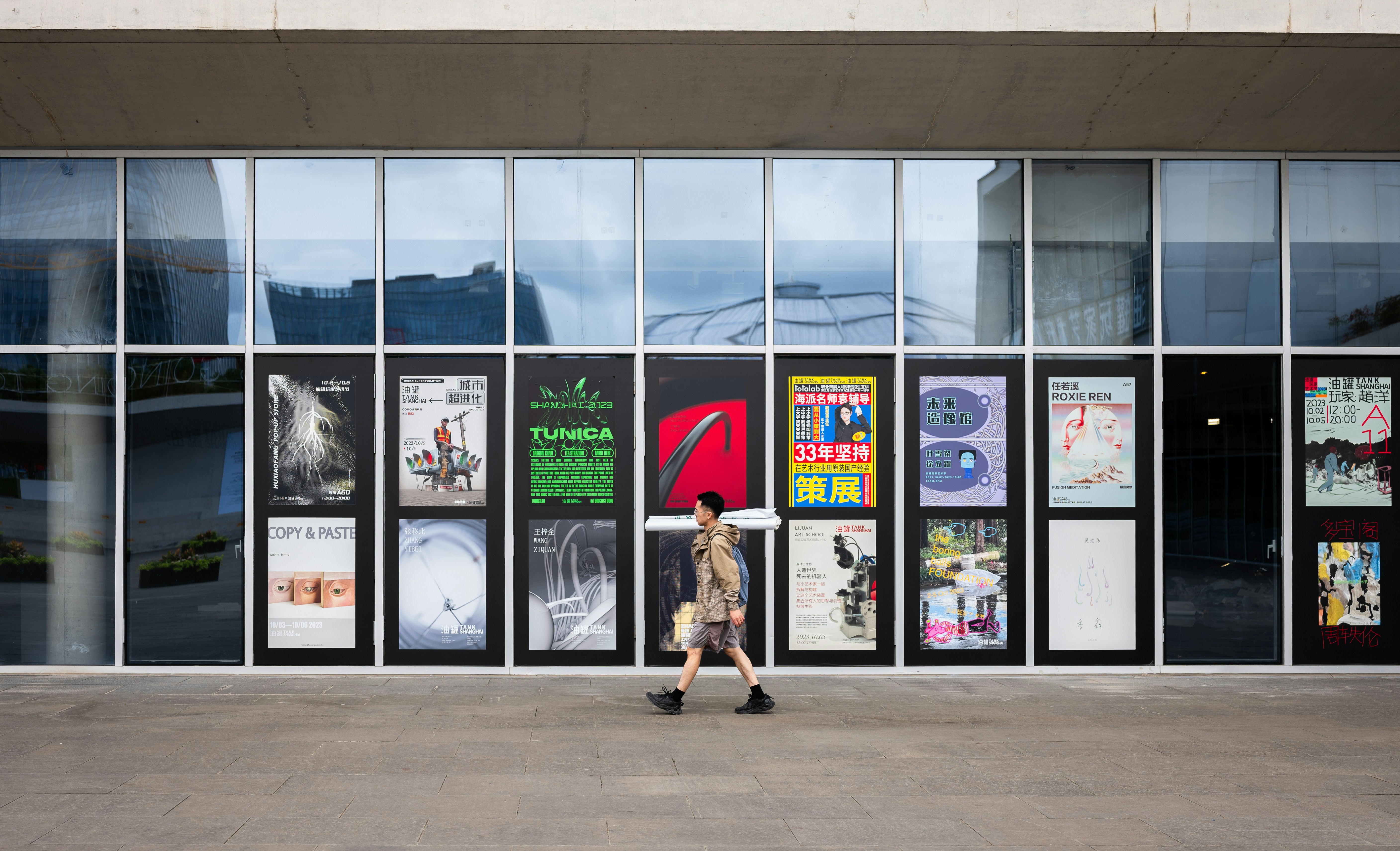 eine Person, die an einem Gebäude mit vielen Fenstern vorbeigeht