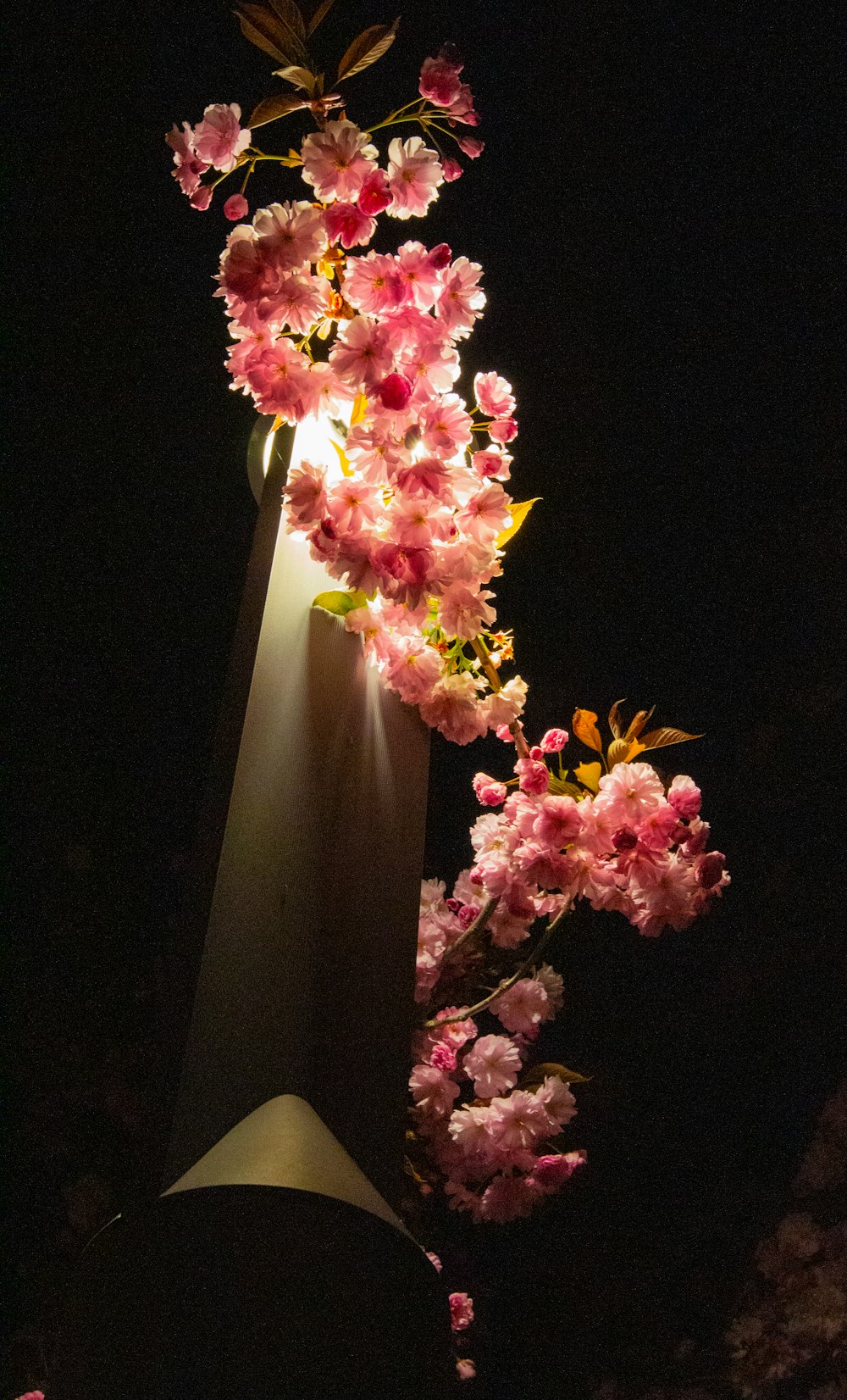 ein hoher Lichtmast mit einem Blumenstrauß darauf