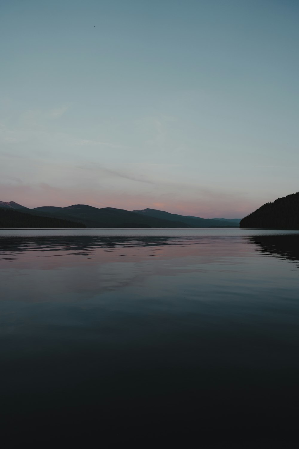 a body of water with mountains in the background